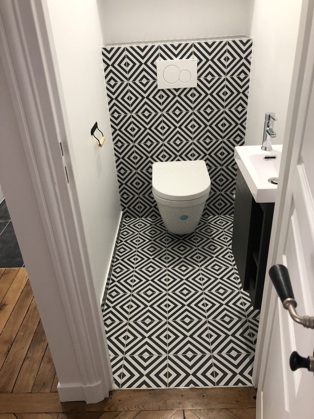 WC suspendu avec carrelage graphique noir et blanc