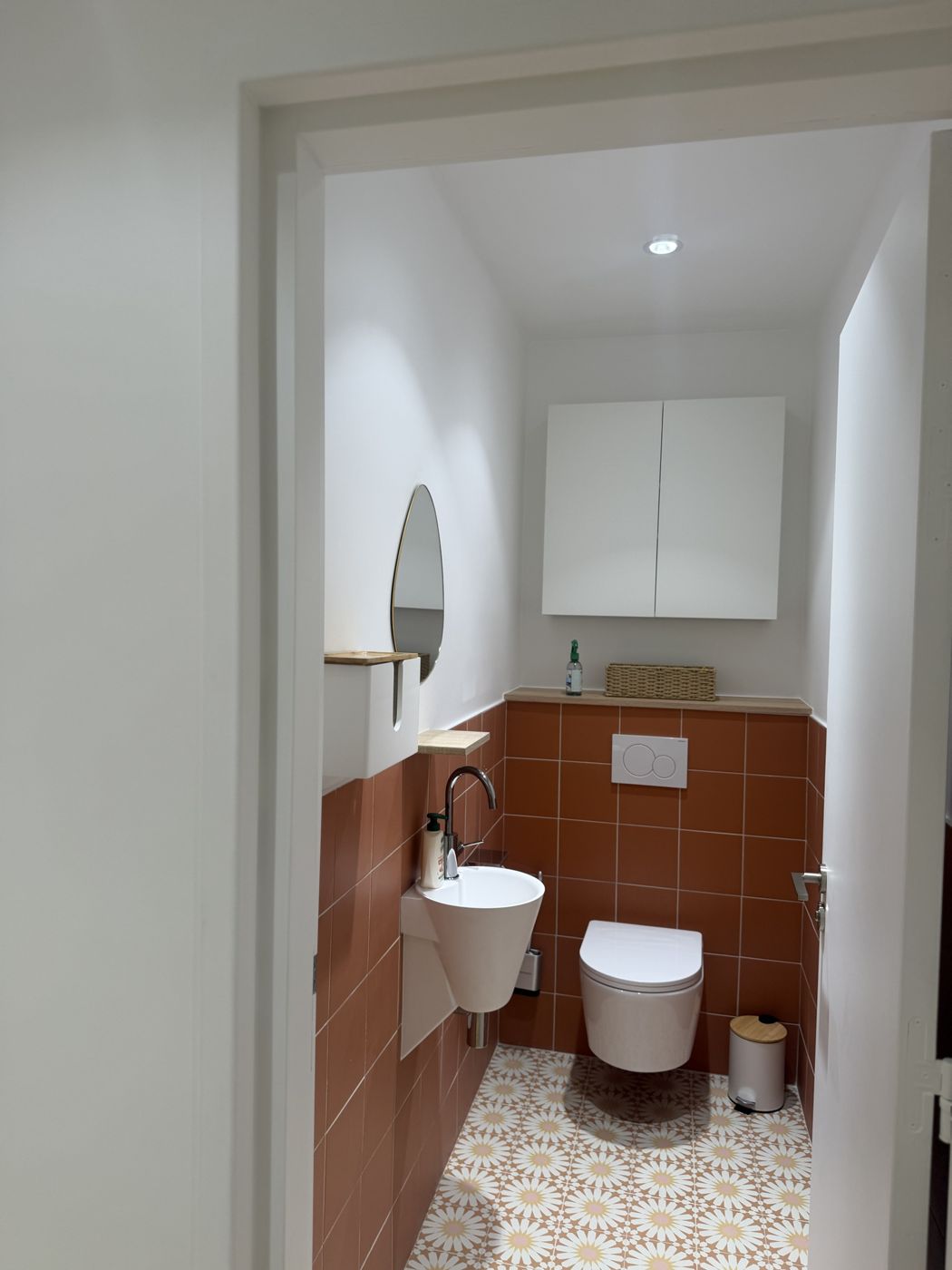 Toilettes avec faïence terracotta et carrelage au sol à motifs de fleurs